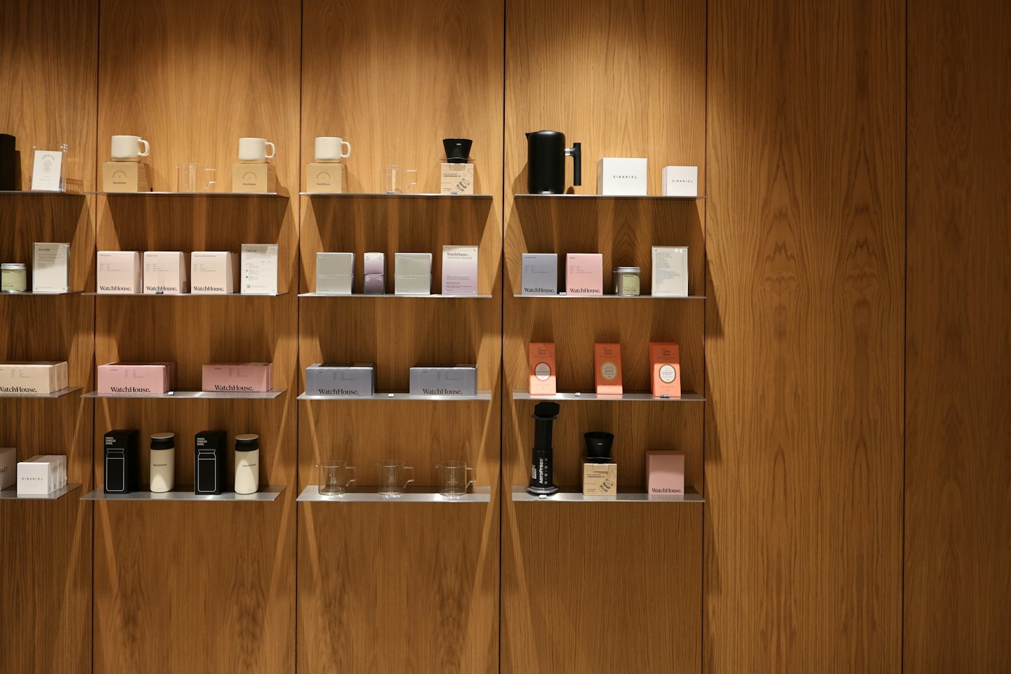 Modern retail display of coffee products on wooden shelves.