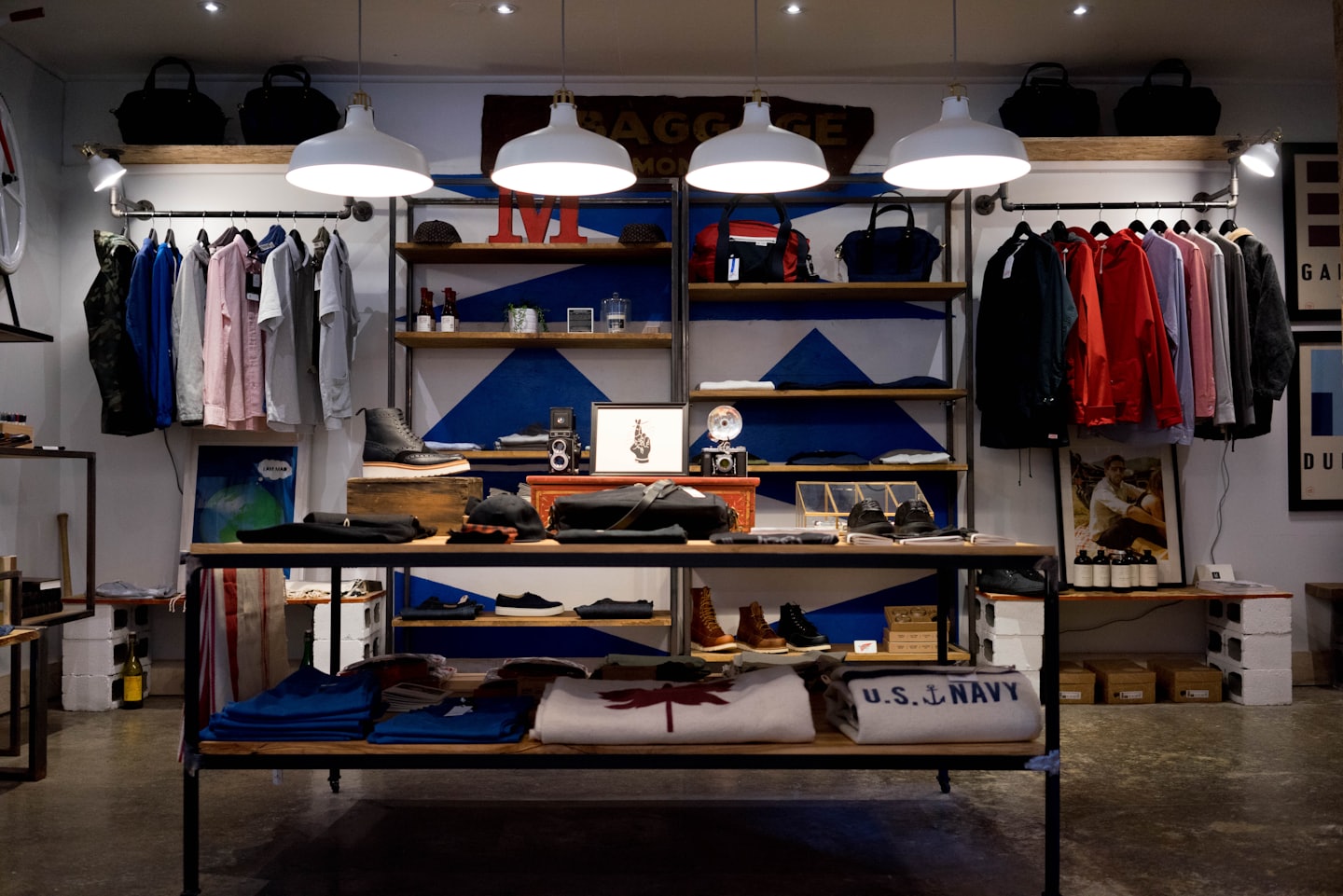 Modern clothing store interior with apparel, shoes, and accessories on shelves.